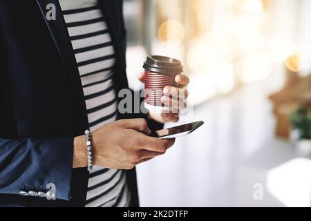 Egli tiene il segreto del successo. Scatto corto di un uomo d'affari che usa un telefono cellulare in un ufficio moderno. Foto Stock