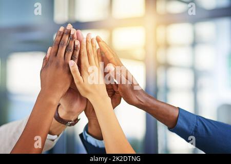 Lavorando insieme, thats il segreto. Un colpo corto di un gruppo di uomini d'affari che si uniscono le mani in solidarietà. Foto Stock