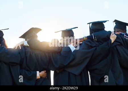 Questo è solo l'inizio. Scatto retroguarato di un gruppo di studenti in fila il giorno della laurea. Foto Stock