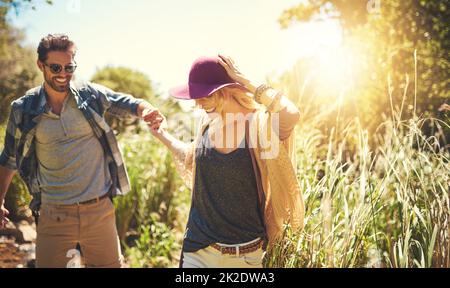 In una fantastica avventura all'aperto. Scatto di una giovane coppia felice esplorando insieme la natura. Foto Stock