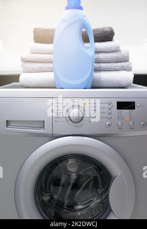 La vostra lavanderia lo amerà. Shot di una lavatrice con asciugamani piegati e detersivo sopra di esso. Foto Stock