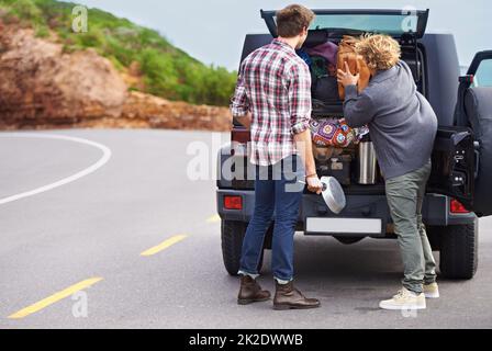 Abbiamo bisogno di un veicolo più grande. Sparato di due persone si fermò sul lato della strada e si reimballò il loro camion. Foto Stock