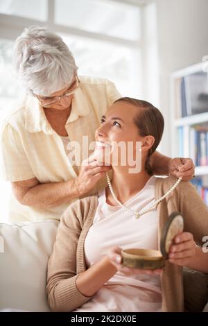 Perle per il mio prezioso. Scatto corto di una donna anziana che dà a sua figlia una collana di perla. Foto Stock