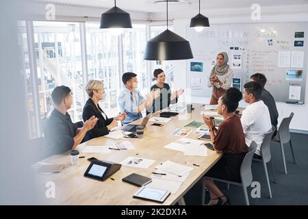 Nessuno dimenticherà questo tipo di conferenza. Scatto di un gruppo di uomini d'affari che si aggrappano durante una riunione in un ufficio moderno. Foto Stock