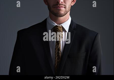 Siete diventati schiavi del commercio. Scatto in studio ritagliato di un uomo d'affari con un cappio legato intorno al collo per una cravatta su sfondo grigio. Foto Stock