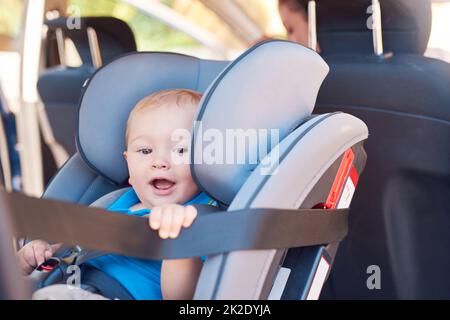 Im off in un'avventura con mamma. Scatto corto di una madre seduta in un'automobile con il suo bambino in un sedile dell'automobile. Foto Stock