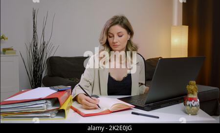 Giovane donna d'affari impegnata che lavora sulla documentazione di progetto. Foto Stock