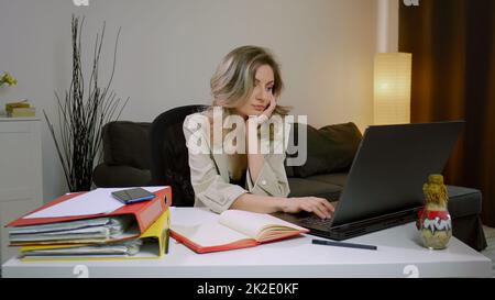 Donna d'affari caucasica addormentata alla scrivania, seduta al tavolo con un computer portatile. Stanco stressato sovraccaricato . Foto Stock