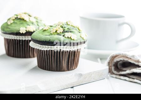 Muffin dolci con glassa al pistacchio. Dessert dolce sul tavolo da cucina. Foto Stock