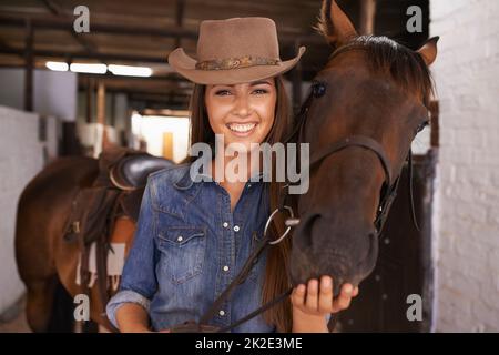 Una migliore amica delle ragazze. Scatto di una giovane donna che tende al suo cavallo. Foto Stock