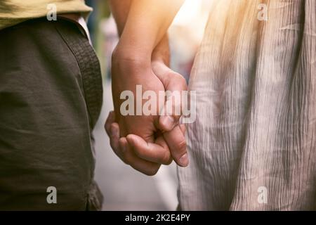 La mia mano avrà sempre spazio per la vostra mano. Scatto corto di una coppia affettuosa che tiene le mani all'aperto. Foto Stock