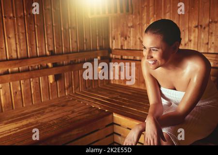 Questa è la sua beatitudine. Scatto corto di una giovane donna che si rilassa nella sauna di un centro benessere. Foto Stock