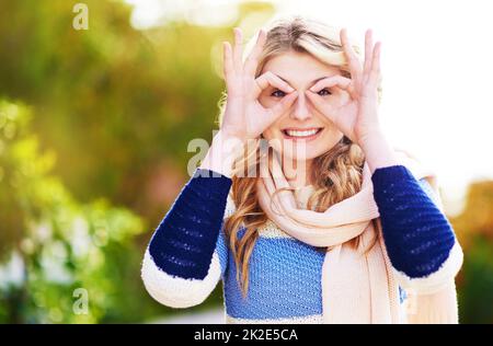 Meglio a vederti con. Ritratto corto di una giovane donna che gesta giocosamente all'aperto. Foto Stock