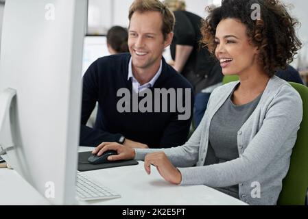 Compiere progressi positivi. Colleghi maschi e femmine che lavorano insieme in modo positivo su un progetto. Foto Stock