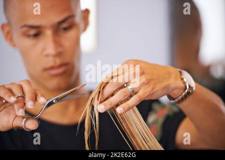 Conosce i capelli. Scatto ritagliato di un parrucchiere maschile che taglia i capelli di un cliente. Foto Stock