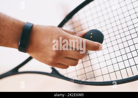 Un buon gioco inizia con un buon servizio. Scatto corto di un uomo che serve una palla con un racket durante una partita di squash. Foto Stock