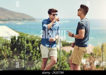 Godersi le vacanze con il mio compagno. Scatto di due bei giovani uomini che beve e si rilassano all'aperto durante le vacanze. Foto Stock