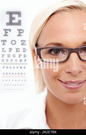 Palpita una vista per gli occhi irritati. Un'immagine ritagliata di un bellissimo optometristo di fronte a una carta di snellen. Foto Stock