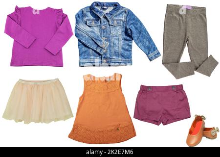 Collage set di abbigliamento primavera bambina isolato su uno sfondo bianco. La collezione di un'elegante giacca di jeans blu, un maglione, una gonna, sneaker, pantaloni e un abito. Moda autunno e inverno per bambini. Foto Stock