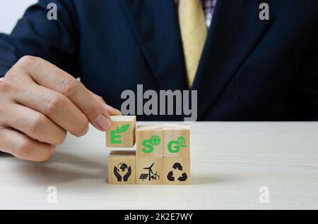 Mettere a mano cubi di legno con ESG Environmental Social Governance simbolo sul tavolo copia space.Business concetti. Foto Stock