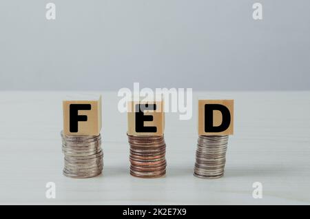 Blocco di cubo di legno sulle monete TESTO ALIMENTATO Business Gestione finanziaria concetti economici. Foto Stock