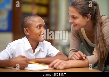 Youre il mio insegnante favorito. Shot di un insegnante che aiuta la sua studentessa con il suo lavoro in aula. Foto Stock