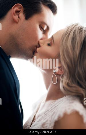 Ho trovato Colui che la mia anima ama. Scatto corto di una giovane coppia affettuosa in piedi insieme e baciare dopo il loro matrimonio. Foto Stock