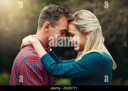 Hanno trovato la felicità l'uno nell'altro. Scatto di una giovane coppia affettuosa che passa il tempo di qualità insieme all'aperto. Foto Stock