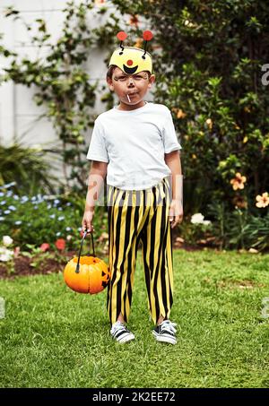 Pronto per trick-or-treating. Ritratto a tutta lunghezza di un adorabile ragazzino in piedi fuori nel suo costume di Halloween. Foto Stock