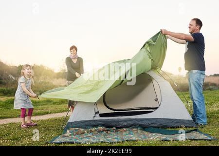 Quasi fatto. Scatto corto di una giovane famiglia che mette insieme una tenda. Foto Stock