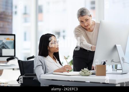 Mostrandole le corde. Scatto corto di una giovane donna d'affari attraente che ottiene alcune informazioni dal suo responsabile delle risorse umane nell'ufficio. Foto Stock