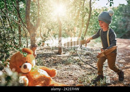 Ecco il cavaliere più coraggioso e più bello. Spara di un adorabile ragazzino che gioca con una spada di cartone e scudo all'esterno. Foto Stock