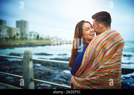 Chi ha detto che hai bisogno di un letto per coccolare. Scatto di una giovane coppia felice che passa una giornata romantica insieme all'aperto. Foto Stock