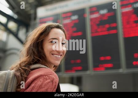 Im andare in vacanza. Ritratto retroguarato di una giovane donna attraente in piedi in un aeroporto. Foto Stock