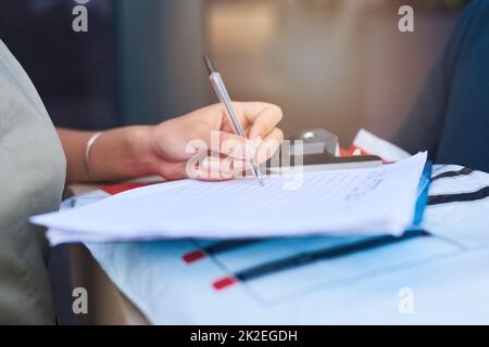 Firma per una consegna riuscita. Primo piano di una giovane donna che canta per una consegna fatta da un corriere. Foto Stock