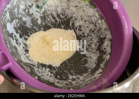 crema di latte di vacca rimanente nel colino, crema di latte di vacca grassa Foto Stock