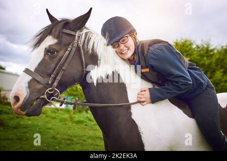 Nessuno la rende felice come il suo cavallo. Sparato di una ragazza adolescente andare a cavallo su un ranch. Foto Stock