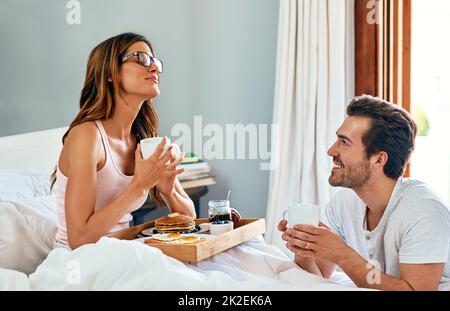 Non avete idea di quanto sono felice in questo momento. Scatto di una giovane coppia felice che si gode la colazione a letto insieme a casa. Foto Stock