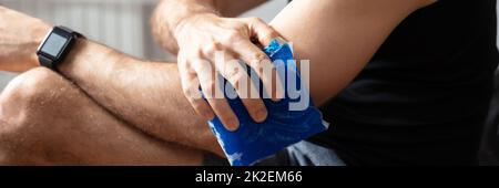 Uomo applicare Ice Bag su gomito Foto Stock