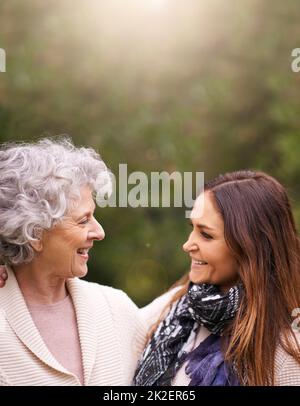 Recuperare con la mamma. Scatto di una donna attraente e la sua madre anziana che parla all'esterno. Foto Stock