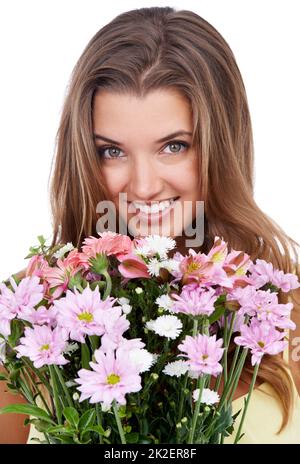 Quasi bello come lei.... Studio girato di una donna attraente che tiene un bouquet di fiori. Foto Stock
