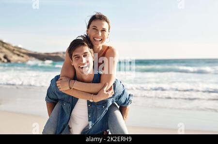 La spiaggia mette tutti in un umore migliore. Scatto di una coppia di mezza età che trascorre la giornata in spiaggia. Foto Stock