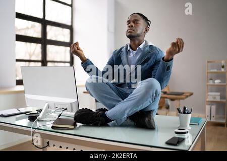 Dipendente africano che fa la salute mentale meditazione Yoga Foto Stock