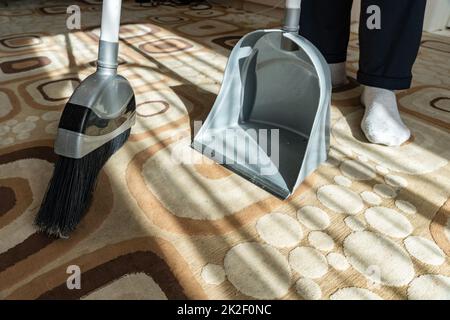 Cleaning.Clean su la spazzatura dal pavimento con una scopa per la pulizia.Sweep via la polvere e lo sporco con una spazzola in un polverpan.Swing il tappeto con una scopa a casa.Indoor strumenti di pulizia. Foto Stock