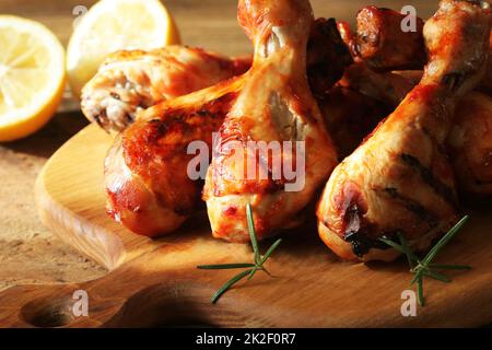 Pollo alla griglia gambe sul bordo di taglio. Sfondo rustico Foto Stock