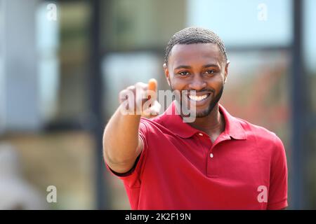 Uomo felice con la pelle nera che punta verso la macchina fotografica Foto Stock