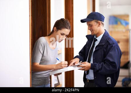 Arriva sempre in orario. Shot di un corriere che effettua una consegna a un cliente sorridente. Foto Stock