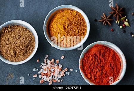 È il momento di fare quel curry. Shot ritagliato di un assortimento di spezie colorate in ciotole. Foto Stock