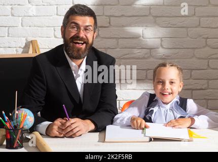 Piccola studentessa felice con un ottimo marchio. Carino bambino prescolare e sorridente insegnante in una classe. Ragazza pupilla carina con faccia felice Foto Stock