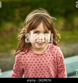 Il mondo per i bambini è pieno di divertimento. Ritratto di una bambina adorabile che si diverte all'aperto. Foto Stock